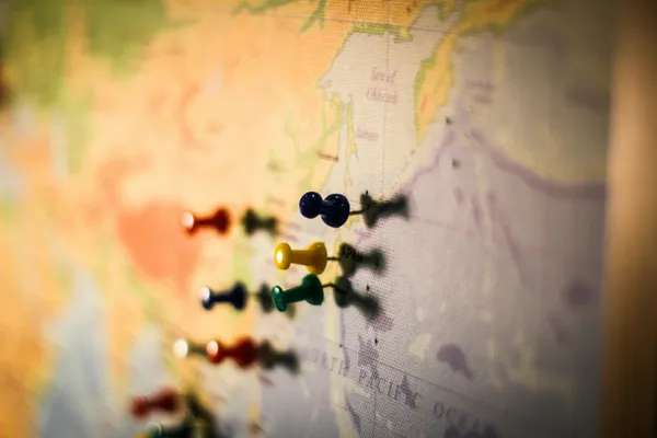 World map with colorful push pins marking top destination countries for Americans after renouncing US citizenship